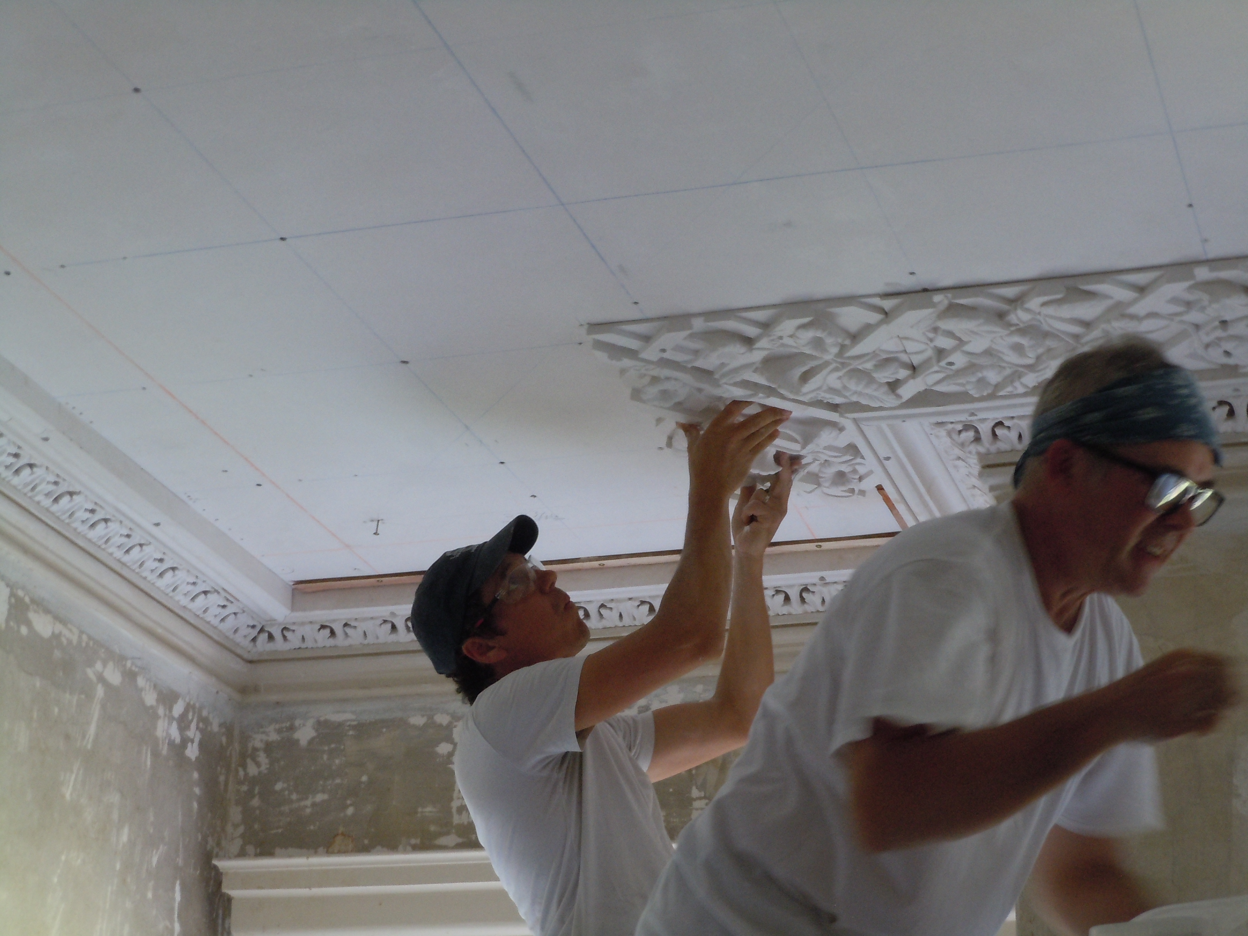 Greg Jacobs and Adam Chase of Landmark Preservation installing the perimeter plaster lattice in the front room.
