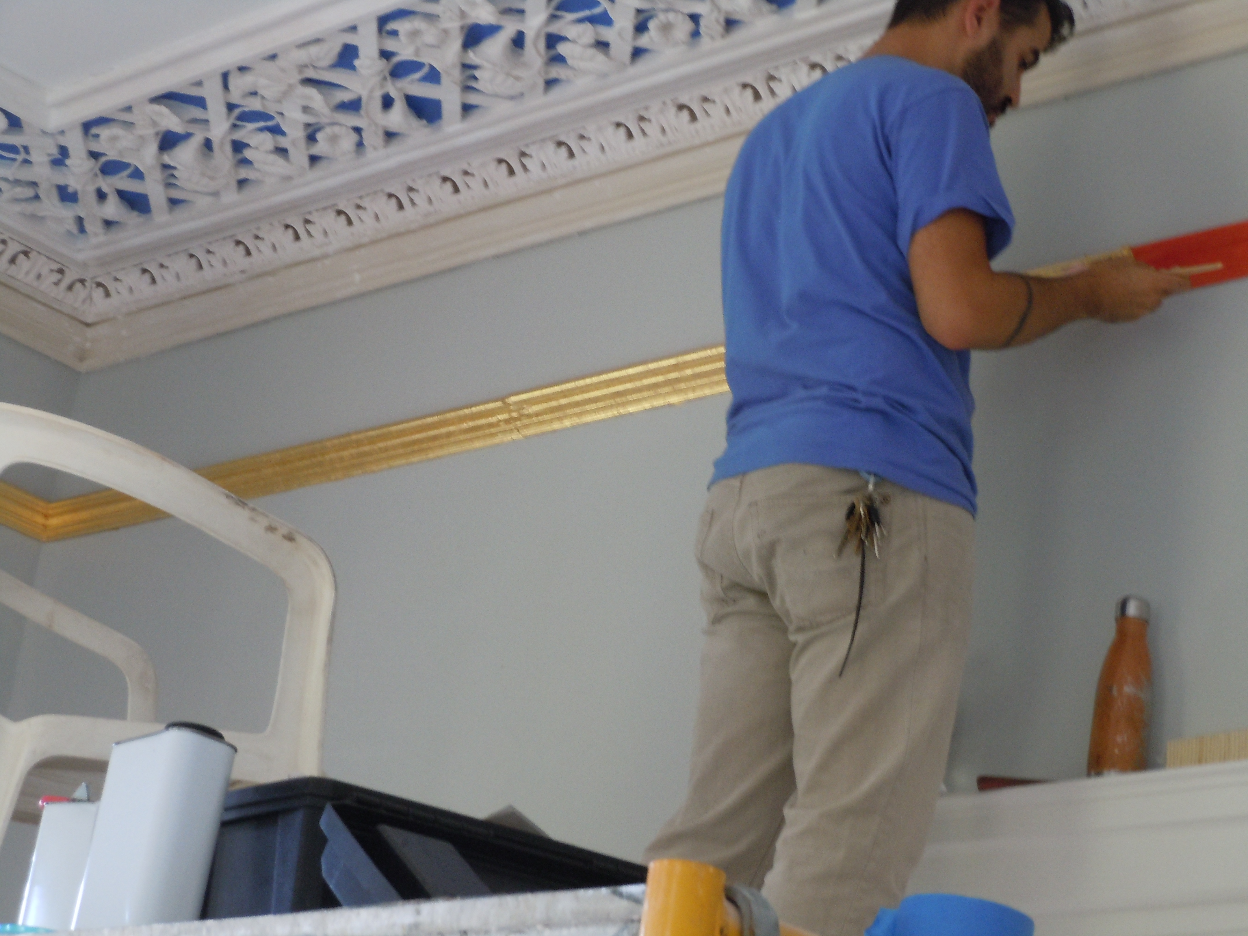  William Santiago of Landmark Preservation gilding the running moulding in Glen Mary’s front room.